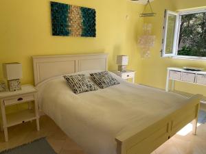 1 dormitorio con 1 cama blanca grande y 2 mesitas de noche en Charming Seaside House next to Beach, en Orebić
