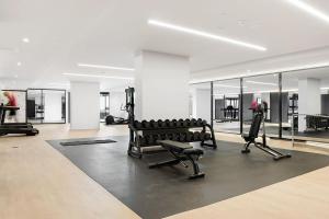 a gym with several treadmills and machines in a room at Cozy Nest in Prime Hawthorn w parking & pool in Melbourne