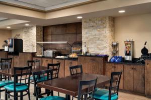 a restaurant with tables and chairs and a kitchen at Baymont by Wyndham Augusta West in Augusta