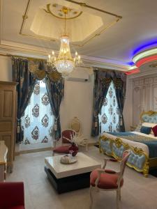 a bedroom with a king sized bed and a chandelier at Suite Présidentielle Maison de L'Église in Narbonne