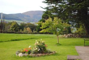 a park with a tree and flowers in the grass at Deerpark Holiday Cottage (1) in Killaloe