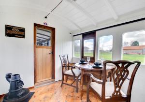 Briston的住宿－The Railway Carriage，一间带木桌和椅子的用餐室