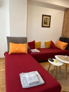 a living room with two red couches with colorful pillows at Golden Lux Apartments in Skopje