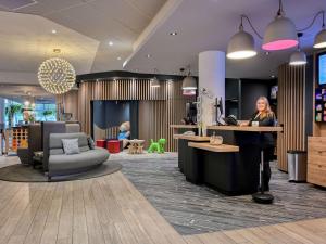 a lobby with a woman sitting at a counter at Novotel Paris Centre Bercy in Paris