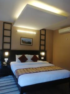 um quarto com uma cama grande e almofadas em Moonlight Resort and Spa em Pokhara