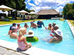 a group of people sitting in a swimming pool at Blanco Guest Farm - Holiday Resort in Tarkastad
