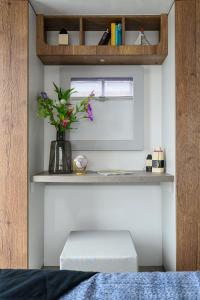 a room with a bench and a vase with flowers at Tiny Olav houseboat close to the beach and restaurants by Weltevreden Experience in Zeewolde