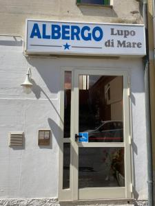 un cartello sulla porta di un negozio di Hotel Lupo di mare a Marina di Castagneto Carducci