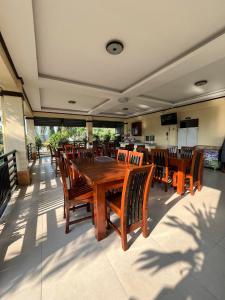 comedor con mesa de madera y sillas en Softwind Villa Hotel and Resort en Santa Catalina