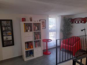 ラヌゼーイにあるAppartamento Ogliastraの本棚と赤い椅子が備わる部屋