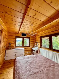 1 dormitorio con 1 cama en una cabaña de madera en LaVerde - Blisko Przyrody Daleko od Tłumu, en Skomielna Czarna