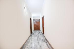 an empty corridor with a wooden door in a room at FabExpress IVY Inn Sector 35 in Noida