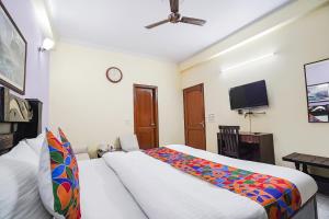a bedroom with a bed and a flat screen tv at FabExpress IVY Inn Sector 35 in Noida