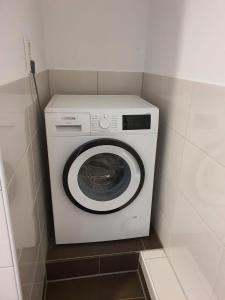 uma máquina de lavar e secar roupa branca num pequeno quarto em Blauwal-1-10-Personen em Brunsbüttel