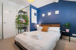 um quarto azul com uma cama com toalhas em Pass the Keys 5 Bollans Court · Charming 2 Bed City Center Apt em York