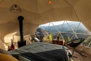 a room with a bed in a tent with a view at Gaia’s Spheres in Gorzegno