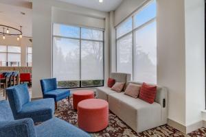 a living room with blue and red chairs and a couch at Hilton Garden Inn Indianapolis Northwest in Indianapolis