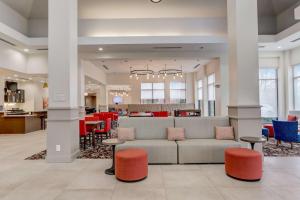a lobby with a couch and tables and chairs at Hilton Garden Inn Indianapolis Northwest in Indianapolis