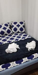 un letto con lenzuola bianche e blu e asciugamani bianchi di Mieszkanie w Centrum Mariacka a Katowice