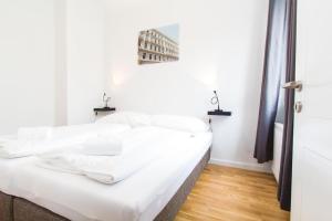 een wit bed in een kamer met witte muren bij Apartment Lainzer Straße in Wenen