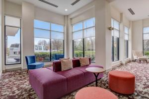 a living room with a purple couch and windows at Hilton Garden Inn Indianapolis Northwest in Indianapolis