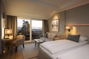 um quarto de hotel com uma cama e um sofá em Scandic Holmenkollen Park em Oslo