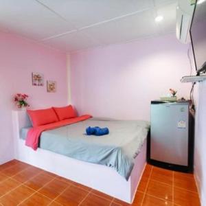 a small bedroom with a bed with pink walls at PRAKAI RESORT in Ban Don Klang