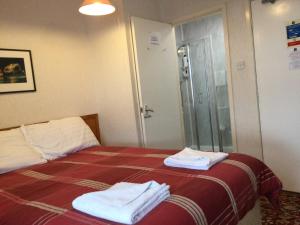 a hotel room with a bed with towels on it at THE TREVONE, Llandudno in Llandudno