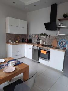- une cuisine avec des appareils blancs et une table en bois dans l'établissement Przestronne mieszkanie w centrum Chorzowa, à Chorzów