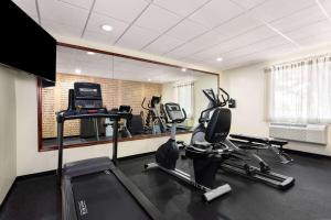 a gym with several tread machines and a mirror at La Quinta by Wyndham Bonita Springs Naples North in Bonita Springs