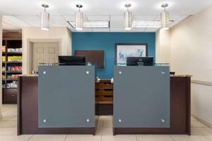 a lobby with blue walls and a desk with a laptop at La Quinta by Wyndham Bonita Springs Naples North in Bonita Springs