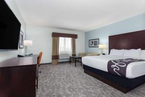 a hotel room with a bed and a flat screen tv at La Quinta by Wyndham Bonita Springs Naples North in Bonita Springs