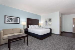 a hotel room with a bed and a couch at La Quinta by Wyndham Bonita Springs Naples North in Bonita Springs