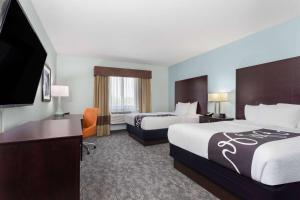 a hotel room with two beds and a flat screen tv at La Quinta by Wyndham Bonita Springs Naples North in Bonita Springs