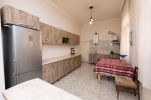 a kitchen with a stainless steel refrigerator and a table at Anna's Guest House in Gori