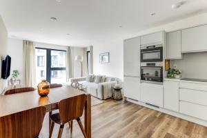 una cucina e un soggiorno con tavolo e divano di The Wandsworth Luxury Apartment a Londra