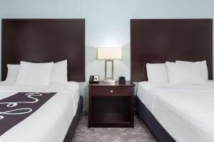 a hotel room with two beds and a lamp on a table at La Quinta by Wyndham Bonita Springs Naples North in Bonita Springs