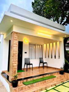 een huis met twee stoelen op een houten terras bij Marari Eshban Beach Villa in Alleppey