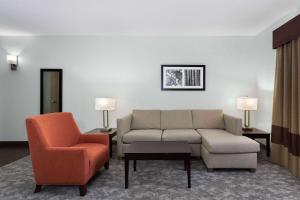 a living room with a couch and a chair at La Quinta by Wyndham Bonita Springs Naples North in Bonita Springs