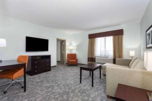 a living room with a couch and a flat screen tv at La Quinta by Wyndham Bonita Springs Naples North in Bonita Springs