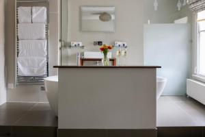 een witte badkamer met een bad en een wastafel bij The Goudhurst Inn in Goudhurst