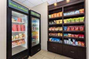 a store aisle with two refrigerators and food at La Quinta by Wyndham Bonita Springs Naples North in Bonita Springs