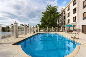 a large blue swimming pool next to a building at La Quinta by Wyndham Bonita Springs Naples North in Bonita Springs