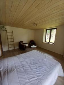 Cette chambre comprend un grand lit et un plafond en bois. dans l'établissement Le regit, Studio moderne Balneo, à La Bresse
