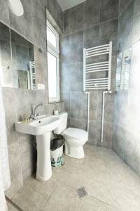 een badkamer met een wastafel, een toilet en een spiegel bij Anna's Guest House in Gori