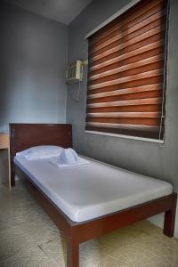 Bett in einem Krankenhauszimmer mit Fenster in der Unterkunft Bethany Suites in Dipolog City