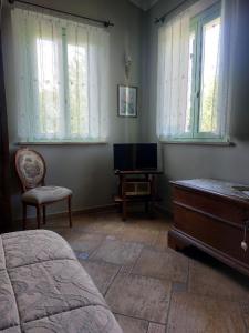 a bedroom with a bed and a dresser and a television at Locanda Antico Casale Cesenatico in Cesenatico