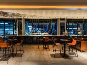 a restaurant with a view of the city at night at Pullman Tokyo Tamachi in Tokyo