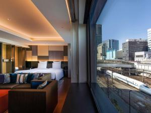 a hotel room with a bed and a large window at Pullman Tokyo Tamachi in Tokyo