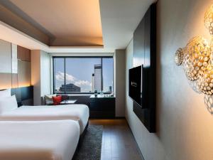 a hotel room with two beds and a window at Pullman Tokyo Tamachi in Tokyo
